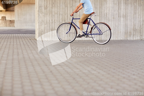 Image of hipster man riding fixed gear bike