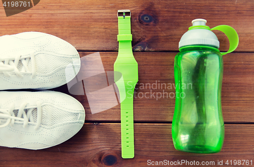 Image of close up of sneakers, bracelet and water bottle