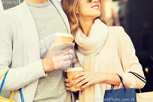 Image of close up of couple with shopping bags and coffee