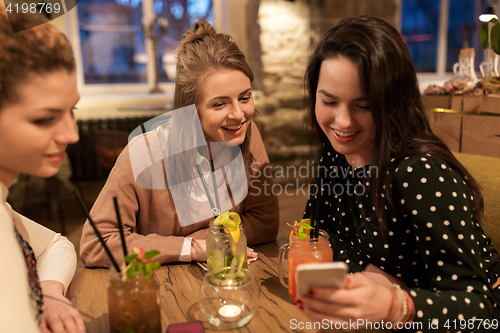 Image of happy friends with drinks at restaurant