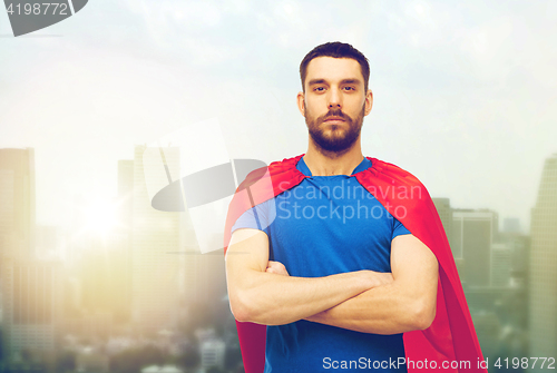 Image of man in red superhero cape over city background