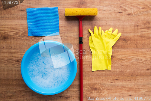 Image of basin with cleaning stuff on wooden background