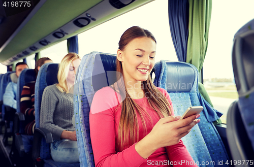 Image of happy woman sitting in travel bus with smartphone