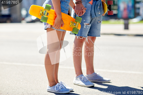 Image of close up of young couple with skateboards in city