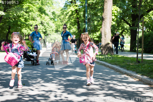 Image of twins mother with children  in city park