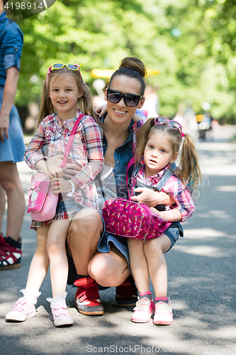 Image of mother with her daughters in the park