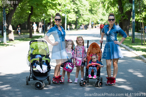 Image of twins mother with children  in city park