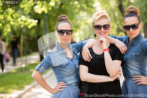 Image of portrait of three young beautiful woman with sunglasses