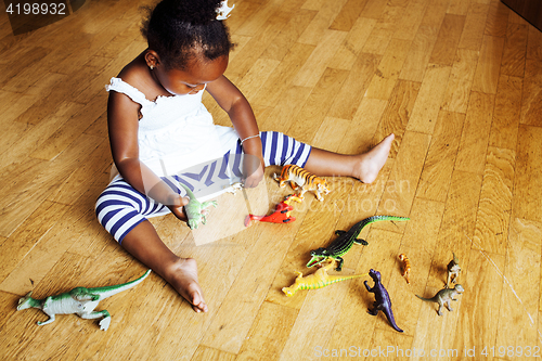 Image of little cute african american girl playing with animal toys at ho