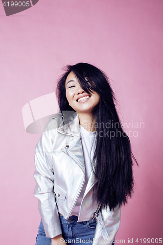 Image of young pretty smiling asian korean girl wearing modern fashion clothers on pink background, lifestyle people concept 