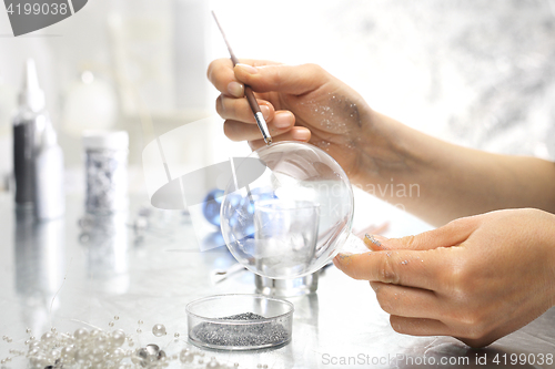 Image of Woman decorate baubles. Christmas tree decorations