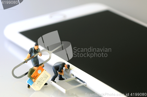 Image of Miniature Workers Installing a SIM Card on a Smart Phone