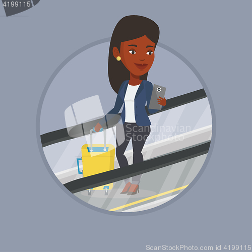 Image of Woman using smartphone on escalator in airport.