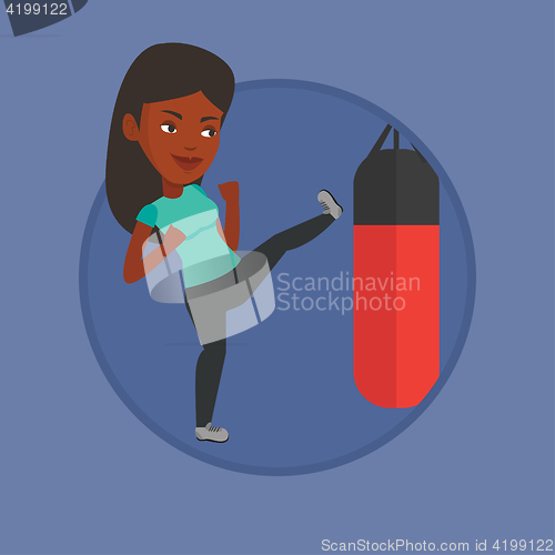 Image of Woman exercising with punching bag.