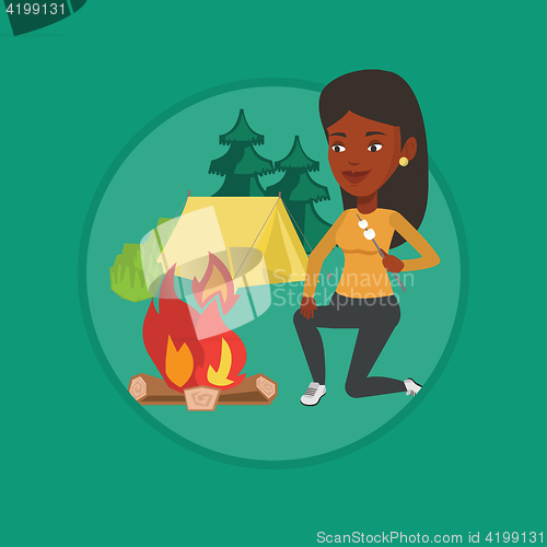 Image of Woman roasting marshmallow over campfire.