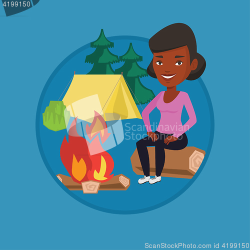 Image of Woman sitting on log near campfire in the camping.