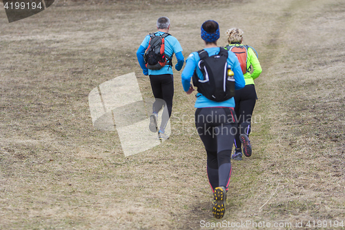 Image of Two women and a man jogging and running outdoors in nature