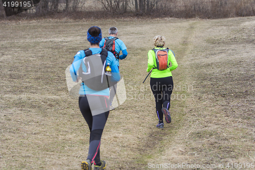 Image of Two women and a man jogging and running outdoors in nature