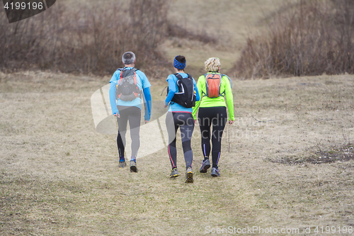 Image of Two women and a man jogging and running outdoors in nature
