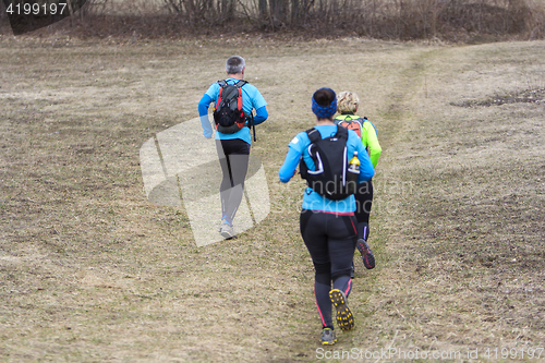 Image of Two women and a man jogging and running outdoors in nature