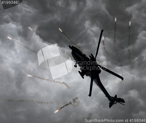 Image of Silhouette of an attack helicopter firing flares
