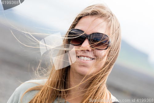 Image of Young woman wearing sunglasses laughing