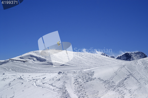 Image of Snowboarder jumping in terrain park at ski resort on sun wind da