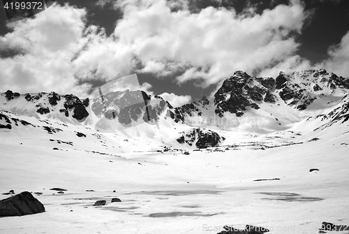 Image of Black and white view on frozen mountain lake covered with snow