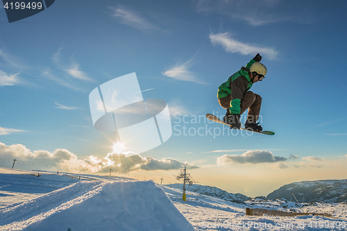 Image of Snowboarder jumping against blue sky