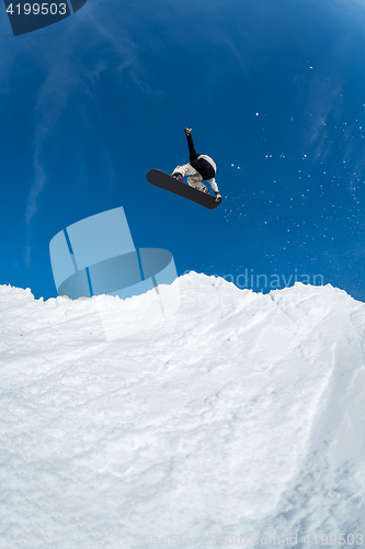 Image of Snowboarder jumping against blue sky