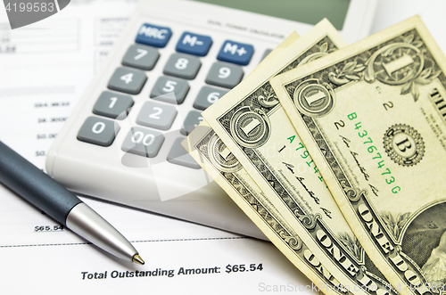 Image of Table with money, calculator and pen