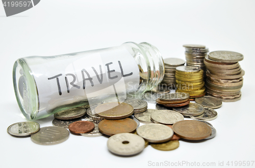 Image of Travel lable in a glass jar with coins spilling out