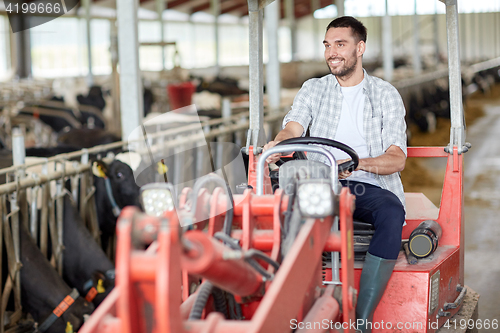 Image of man or farmer driving tractor at farm