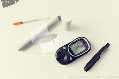 Image of close up of glucometer, insulin pen and syringe