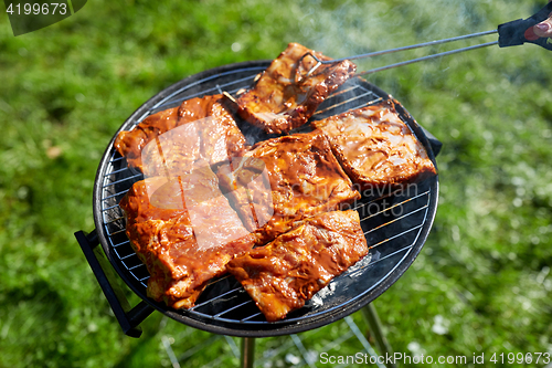 Image of meat cooking on barbecue grill at summer party