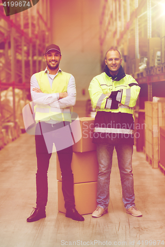 Image of men in uniform with boxes at warehouse