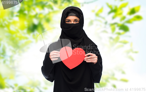 Image of muslim woman in hijab holding red heart