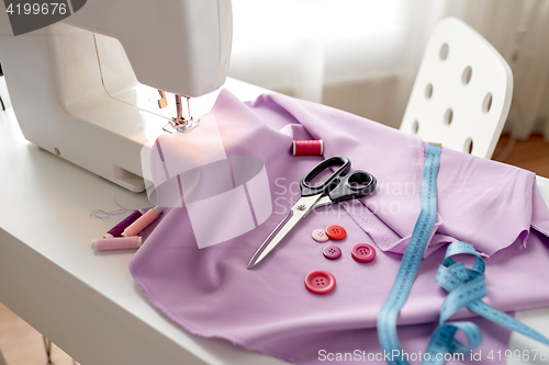 Image of sewing machine, scissors, buttons and fabric