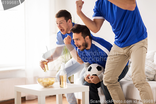 Image of friends or football fans watching soccer at home