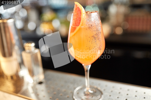 Image of glass of grapefruit cocktail at bar