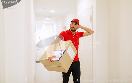 Image of delivery man with box and clipboard in corridor