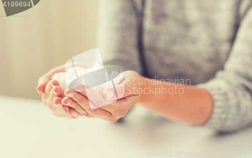 Image of close up of white lump sugar in woman hands