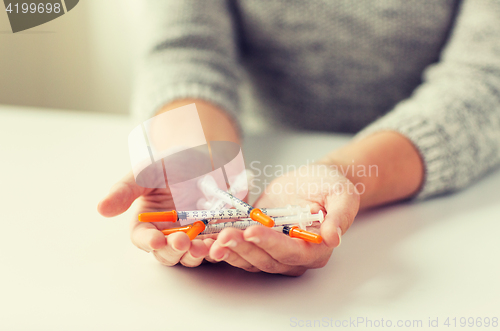 Image of close up of woman hands holding insulin syringes