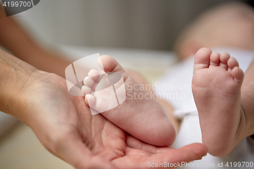 Image of close up of newborn baby feet in mother hands