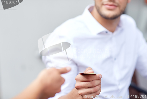 Image of close up of man giving credit card to waiter