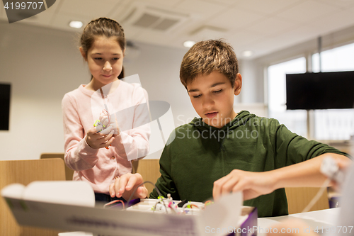 Image of happy children building robots at robotics school