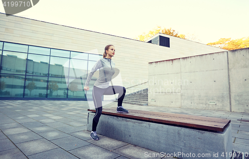 Image of woman exercising on bench outdoors