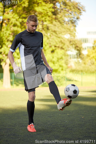 Image of soccer player playing with ball on field