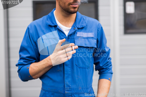 Image of close up of auto mechanic smoking cigarette