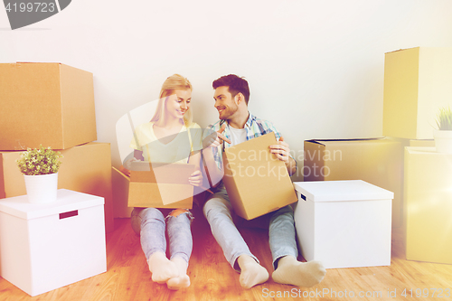 Image of smiling couple with many boxes moving to new home